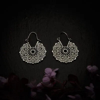 KIWA jewellery brand product image of a pair of silver plated earrings called Bali , set on a dark granite background with dark pink coloured flower decoration on the lower end.