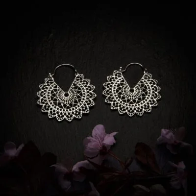 KIWA jewellery brand product image of a pair of silver plated earrings called Basilicum mini version, set on a dark granite background with dark pink coloured flower decoration on the lower end.