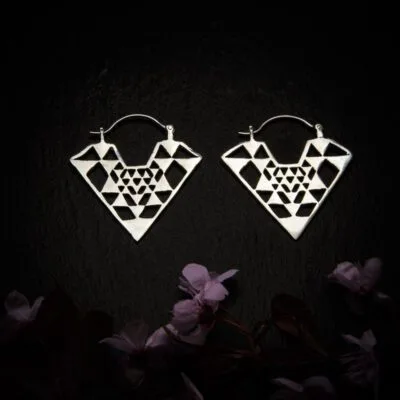 KIWA jewellery brand product image of a pair of silver plated earrings called Diamond , set on a dark granite background with dark pink coloured flower decoration on the lower end.