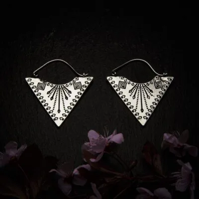 KIWA jewellery brand product image of a pair of silver plated earrings called Etnica, set on a dark granite background with dark pink coloured flower decoration on the lower end.