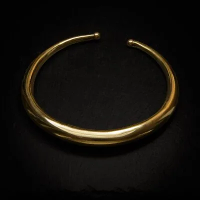 KIWA jewellery brand product image of a single brass necklace called the Femina choker, set on a dark granite background with no decoration
