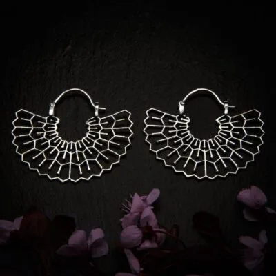 KIWA jewellery brand product image of a pair of silver plated earrings called Happiness, set on a dark granite background with dark pink coloured flower decoration on the lower end.