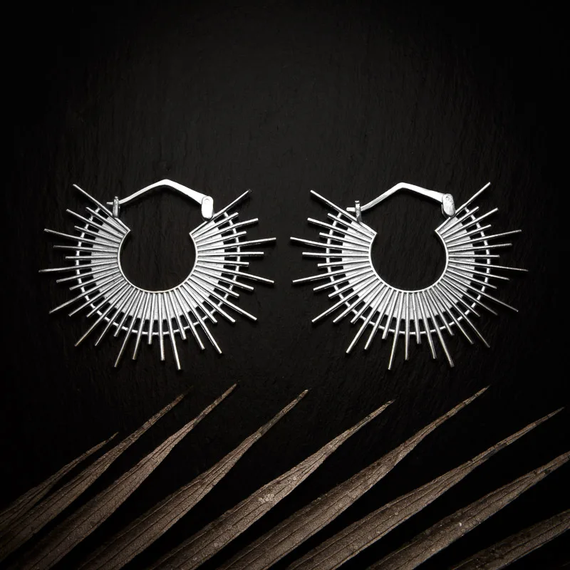 KIWA jewellery brand product image of a pair of silver plated earrings called Ida, set on a dark granite background with light coloured leaf decoration on the lower end.