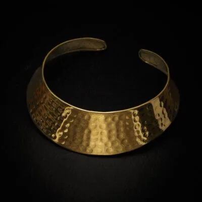 KIWA jewellery brand product image of a single brass material necklace called the Ishtar choker, set on a dark granite background with no decoration