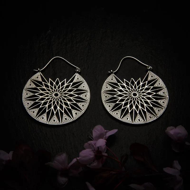 KIWA jewellery brand product image of a pair of silver plated earrings called Laila, set on a dark granite background with dark pink coloured flower decoration on the lower end.