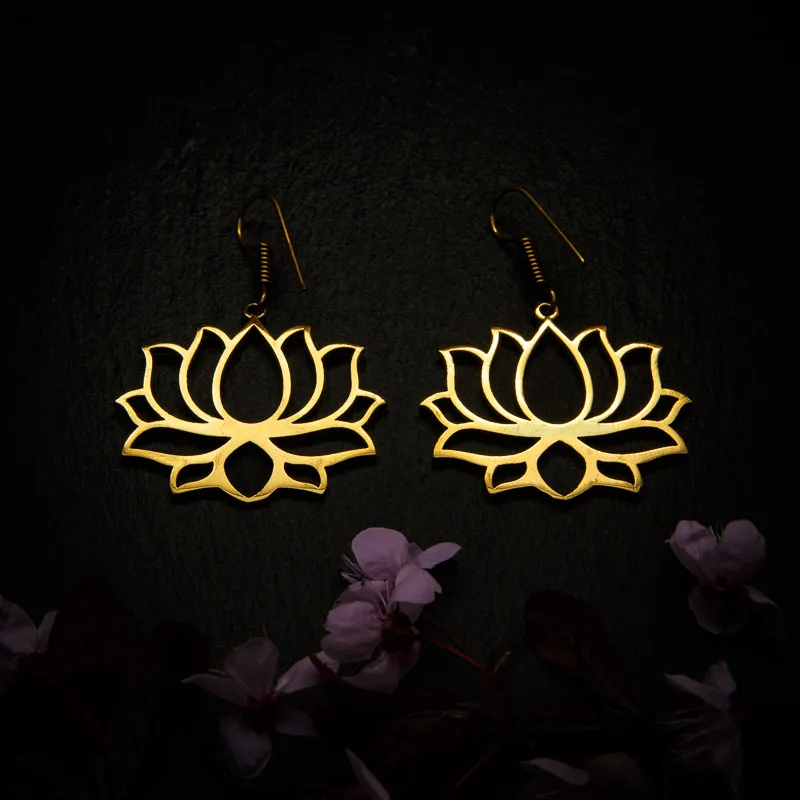KIWA jewellery brand product image of a pair of brass material earrings called Lotus, set on a dark granite background with dark pink coloured flower decoration on the lower end.