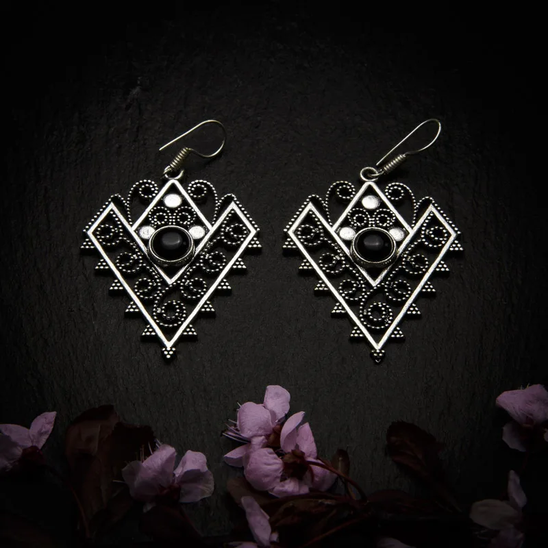 KIWA jewellery brand product image of a pair of silver plated earrings called Love, set on a dark granite background with dark pink coloured flower decoration on the lower end.
