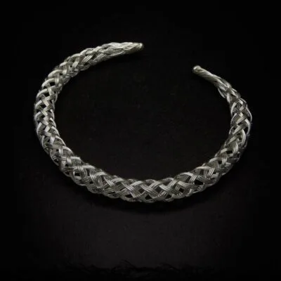 KIWA jewellery brand product image of a single silver plated necklace called the plait choker, set on a dark granite background with no decoration