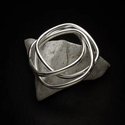 KIWA jewellery brand product image of a single triple silver plated bracelet called Taboo choker set on a dark granite background on a white rock.