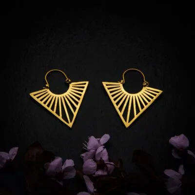 KIWA jewellery brand product image of a pair of brass material earrings called Uma mini version, set on a dark granite background with dark pink coloured flower decoration on the lower end.