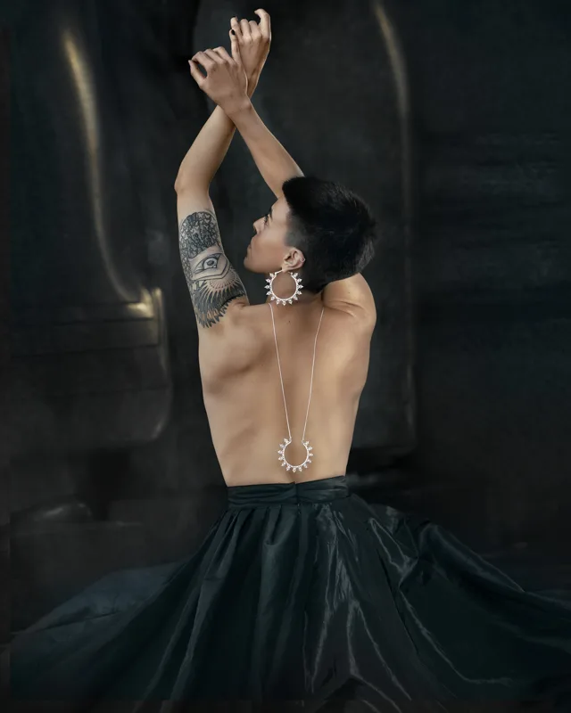 Photo of a Female model wearing Helia Silver plated Earrings and Necklace from KIWA Jewellery handcrafted designs set against a dark background
